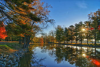 Peaceful autumn landscape of a lake with colorful trees reflecting under morning light. HD wallpaper