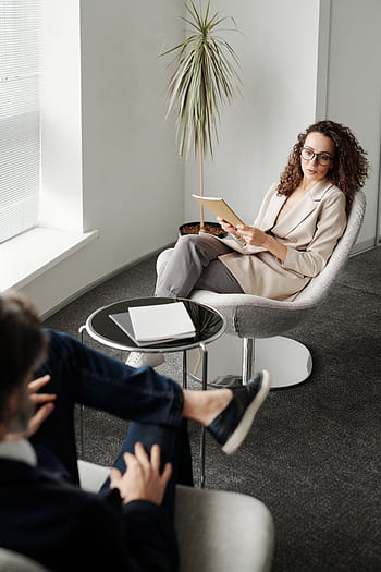 A professional woman conducting a business meeting in a modern office. HD phone wallpaper