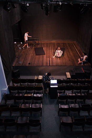 Actors rehearsing on stage in an empty theater, viewed from above. HD phone wallpaper