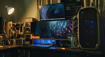 A cozy indoor modern computer setup with dual monitors and creative lighting. HD wallpaper