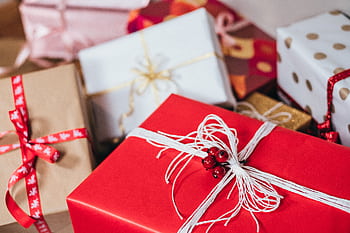 Close-up of festively wrapped Christmas gifts with ribbons and bows. HD wallpaper