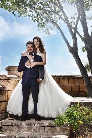 Romantic outdoor wedding of a happy couple embracing under a tree. HD phone wallpaper
