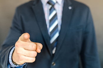 A businessman in a dark suit points forward, emphasizing focus and professionalism. HD wallpaper