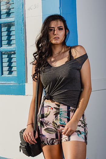 Stylish woman posing outdoors in a casual summer outfit with vibrant colors. HD phone wallpaper