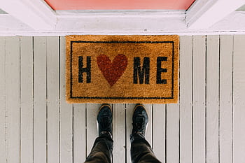 A creative doormat with heart motif symbolizing home at a front porch entrance. HD wallpaper