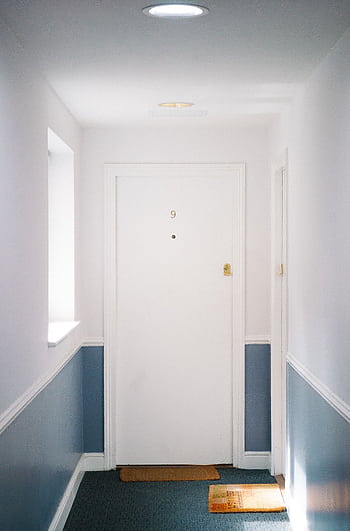 Bright minimalist hallway with door number 9 in a London apartment, capturing simple elegance. HD phone wallpaper
