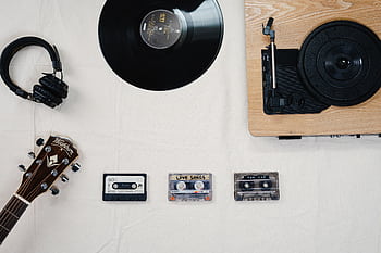Flat lay of guitar, vinyl, cassettes, and heads showcasing a classic music collection. HD wallpaper