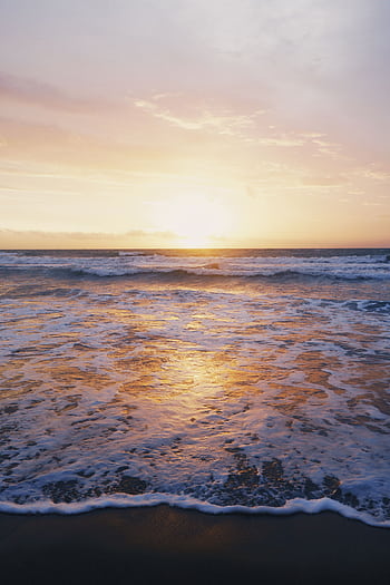 Capture the serene beauty of Bali's beach sunset with golden reflections on the ocean waves. HD phone wallpaper