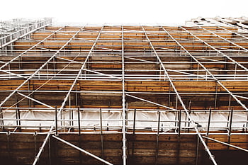A detailed view of scaffolding at a construction site shows structure and pattern. HD wallpaper