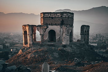 Aged ruins of King Nader Shah's tomb with a backdrop of Kabul city at dusk, displaying rich history. HD wallpaper