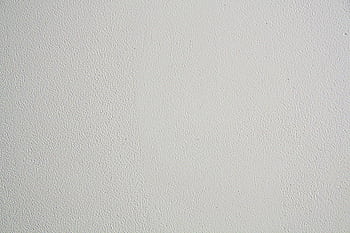 Close-up of a textured white wall, ideal for backgrounds in design projects. HD wallpaper