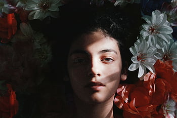 Captivating portrait of a woman with deep shadow and colorful flowers in Barranquilla. HD wallpaper