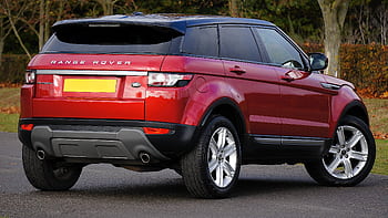 Elegant red Range Rover SUV parked outdoors on a clear day, showcasing its luxury and style. HD wallpaper