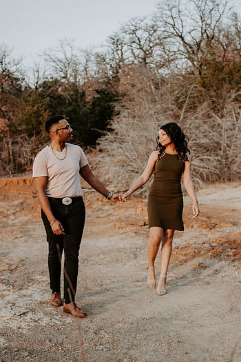 Romantic couple walking hand in hand in a natural setting during the day. HD phone wallpaper