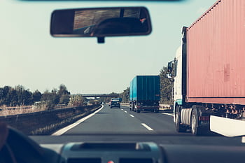 View through rearview mirror of trucks on a German highway, driving towards Bamberg. HD wallpaper