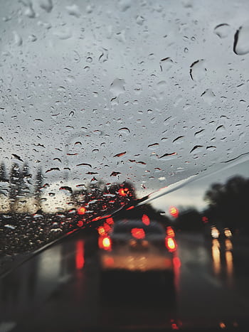 View of blurred traffic lights through a rain-covered windshield on a gloomy evening. HD phone wallpaper