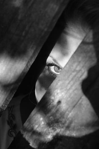 A woman's eye peeks through wooden planks, creating a mysterious and enigmatic scene. HD phone wallpaper