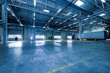 Large warehouse interior with docked truck, ideal for logistics and warehousing. HD wallpaper