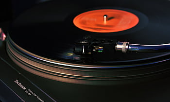 Close-up of a vintage turntable playing a vinyl record, showcasing analog technology. HD wallpaper