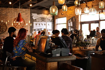 A bustling café in Miami with people enjoying a lively atmosphere and stylish interior design. HD wallpaper