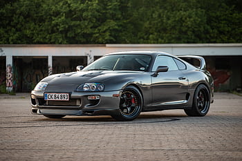 A stylish Toyota Supra supercar parked outdoors in Næstved, Denmark, showcasing its sleek design. HD wallpaper