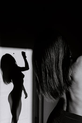 Artistic silhouette of a nude woman in black and white, emphasizing form and shadow. HD phone wallpaper