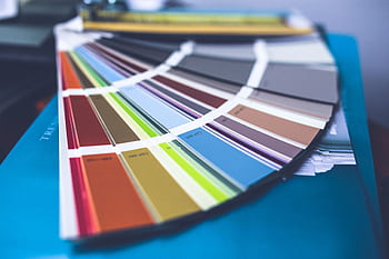 A collection of colorful paint swatches spread out showcasing a variety of hues. HD wallpaper