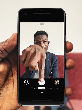Portrait of a man using a smart to take a selfie indoors. HD phone wallpaper