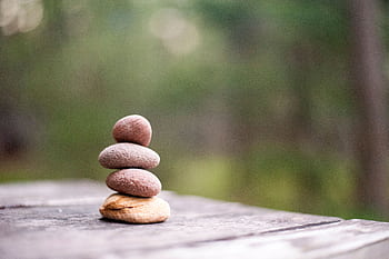Balance and tranquility embodied by stacked stones in a natural outdoor setting. HD wallpaper