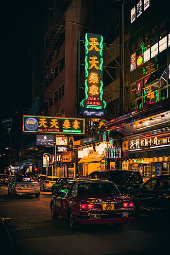 Exploring the vibrant nightlife of Hong Kong with neon signs illuminating the busy streets. HD phone wallpaper