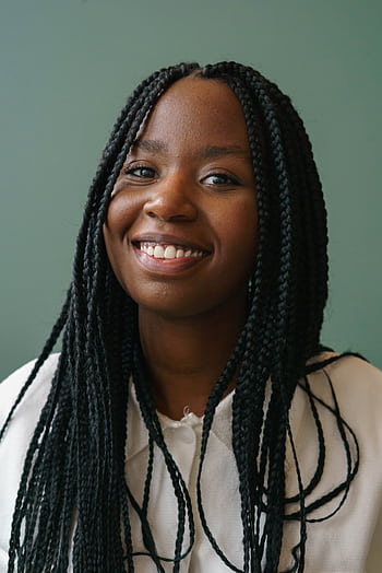 Close-up portrait of a cheerful young woman with braided hair against a green background. HD phone wallpaper