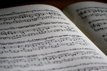 Detailed close-up of a music sheet showing complex musical notes and compositions. HD wallpaper