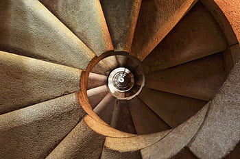 Close-up view of a spiral stone staircase showcasing intricate geometric patterns. HD wallpaper