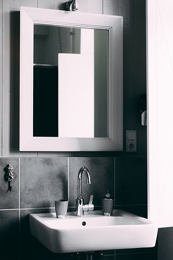 Contemporary bathroom showcasing a sleek sink and framed mirror, perfect for modern interior designs. HD phone wallpaper