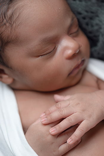 A close-up of a peaceful newborn baby sleeping wrapped in a soft blanket. HD phone wallpaper