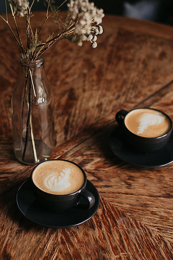 Aesthetic café setting with two cappuccinos on a wooden table and dried flowers. HD phone wallpaper