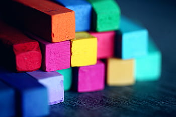 Close-up of stacked colorful pastel chalks, showcasing a vibrant array of colors and textures. HD wallpaper