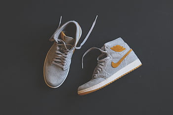Close-up of fashionable gray and orange high-top sneakers displayed against a minimal background. HD wallpaper