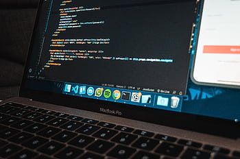Close-up of a laptop with code on the screen, perfect for illustrating programming concepts. HD wallpaper