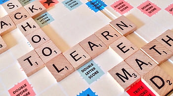 Close-up of Scrabble tiles forming words related to education and school. HD wallpaper