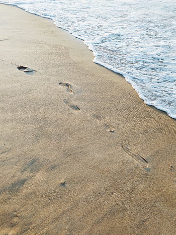 Sandy beach with footprints near ocean waves, perfect summer day. HD phone wallpaper
