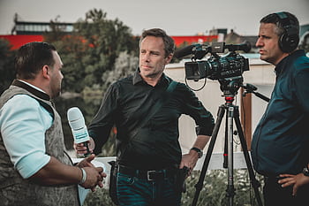 Outdoor interview with a professional news crew capturing footage using high-tech equipment. HD wallpaper