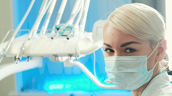 Closeup face of young woman dentist in mask on her in dental office. Video portrait of beautiful doctor or nurse. beautiful woman with blond braided hair in ... HD wallpaper