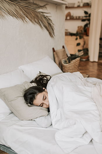 A peaceful woman sleeping comfortably in a cozy, minimalistic bedroom. HD phone wallpaper