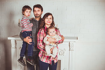 A joyful family posing together in a cozy living room, embodying love and togetherness. HD wallpaper