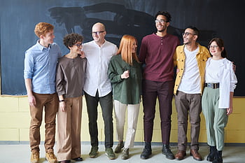 A multicultural group of six adults standing happily together in a casual setting. HD wallpaper