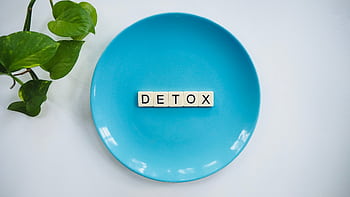 Minimalist concept of detox with letter tiles on a turquoise plate and green leaves. HD wallpaper
