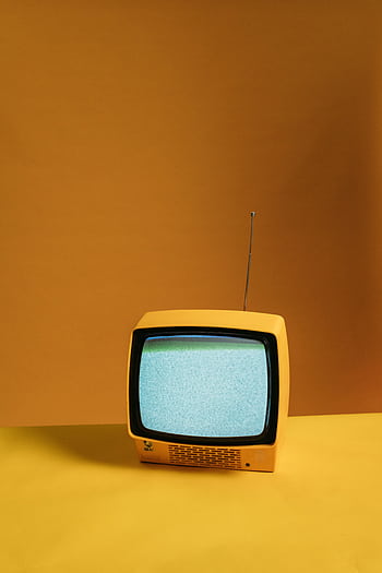 Vintage yellow television with static screen on an orange backdrop creating a nostalgic vibe. HD phone wallpaper