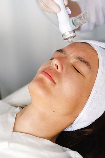 Woman receiving a facial spa treatment, promoting skincare rejuvenation and wellness. HD phone wallpaper