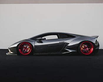 Grey Lamborghini sports car with distinctive red rims parked outdoors. HD wallpaper